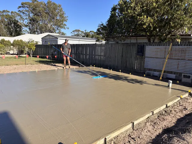 Freshly poured shed slab being screeded