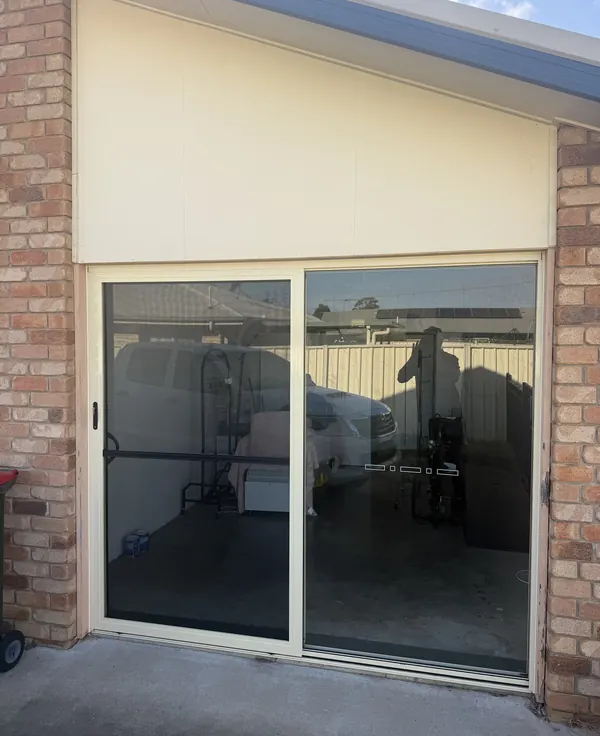 Sliding door and cladding fitted into a brick opening